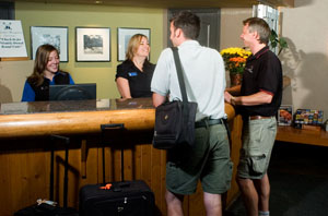 Front desk staff welcoming guests at Deer Lodge check-in